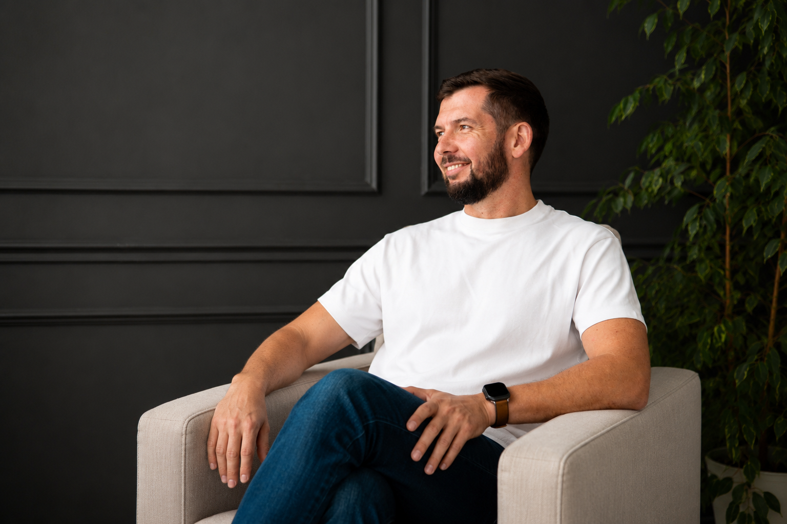 Martin Repinski seated in an armchair against a dark background